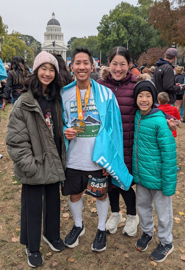 I'm wearing the CIM medal and standing with my wife, and our 13-year old twins outdoors after the race.